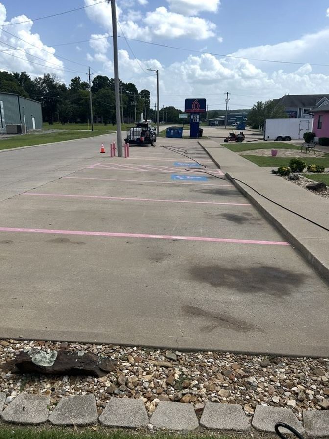 Commercial parking lot concrete with dark stains, before pressure washing